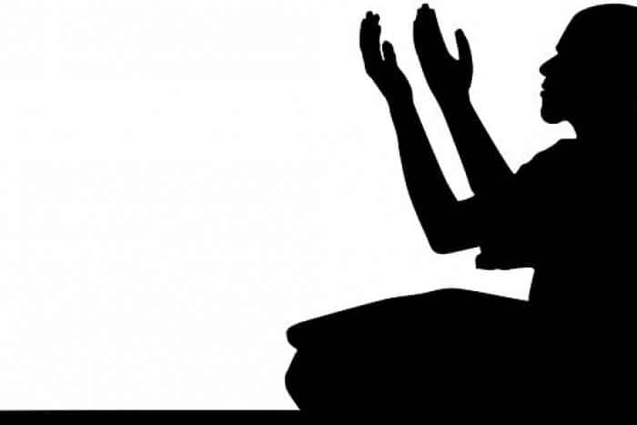 Black nd white illustrantion of someone sitting with hands held upward