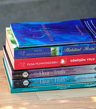 Stack of alstack of books by author Musa Muhaiyaddeen
